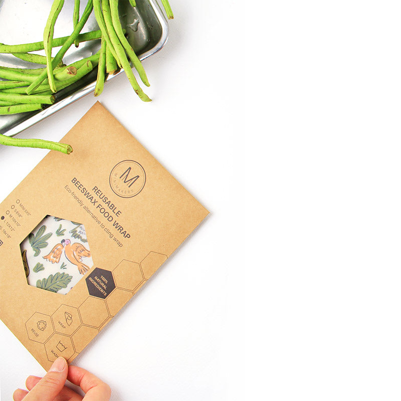 minimakers beeswax wraps in polly parrot print inside kraft paper packaging next to long bean