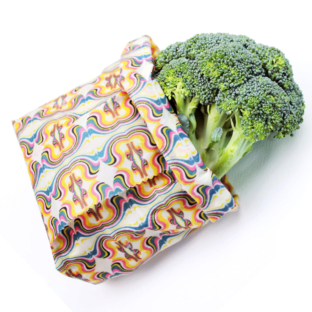 minimakers extra large beeswax wrap garlic in psychedelic print folded into wax bag keeping broccoli fresh