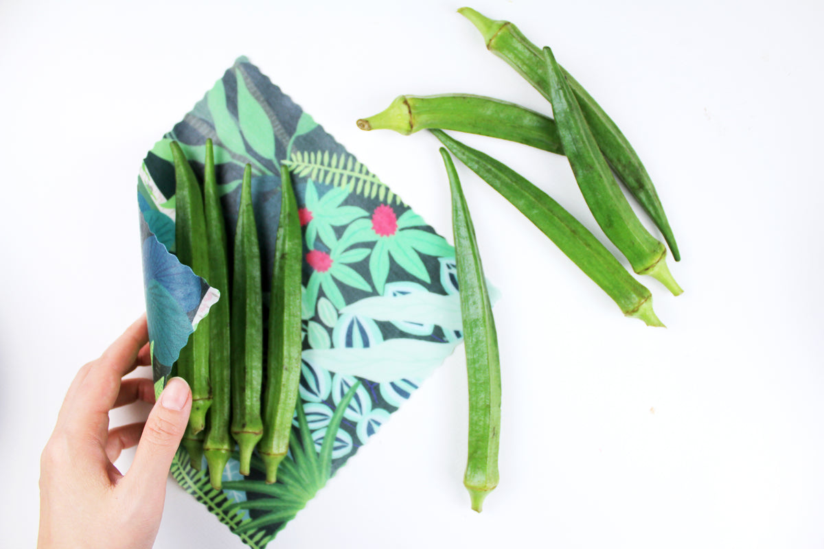 lifestyle image of singapore botanic gardens print wrapping ladyfingers in premium cotton beeswax wraps by em+co art in collaboration with minimakers (local designer) singapore
