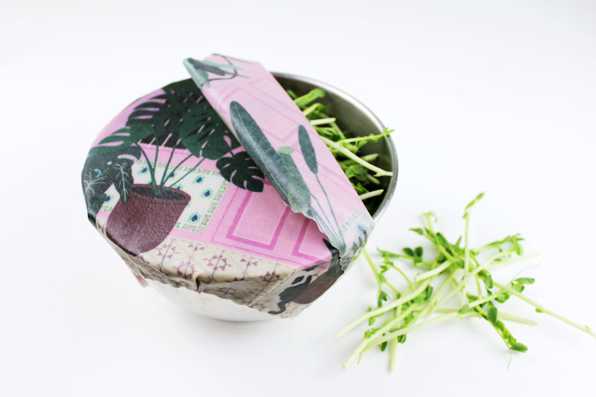 lifestyle image of pink singapore shophouse print covering bowl of microgreen in premium cotton beeswax wraps by em+co art in collaboration with minimakers (local designer) singapore